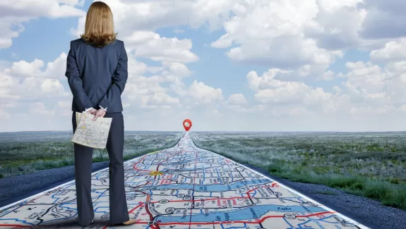 Woman looking down a long road that appears to be a map